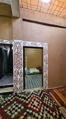 a mirror on a wall in a room with a rug at Dar salam in Mhamid