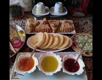 a table with plates of pastries and dipping sauce at Dar salam in Mhamid