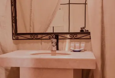a bathroom with a sink and a mirror at Sandrock Luxury Camp in Merzouga