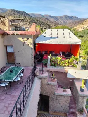 an outdoor patio with a table and a tent at Hôtel Tawada in Azilal