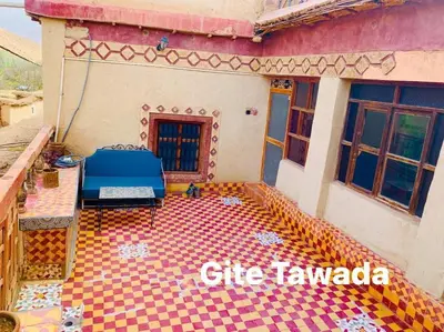 a house with a blue bed on a checkered floor at Hôtel Tawada in Azilal