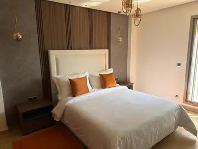 a bedroom with a large white bed with orange pillows at The Hermes pearl in Fès