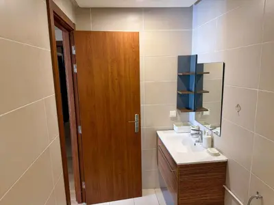 a bathroom with a sink and a wooden door at The Hermes pearl in Fès