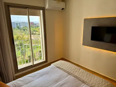 a bedroom with a bed and a large window at The Hermes pearl in Fès