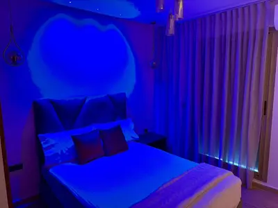 a bedroom with a bed with a blue hue at The Hermes pearl in Fès