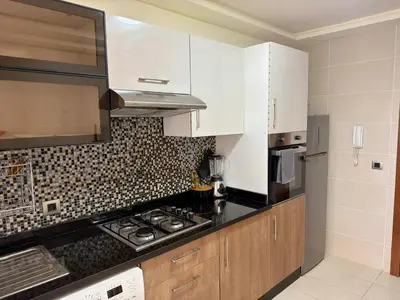 a kitchen with white cabinets and a stove top oven at The Hermes pearl in Fès