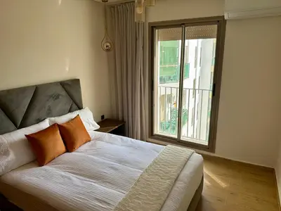 a bedroom with a bed with orange pillows and a window at The Hermes pearl in Fès