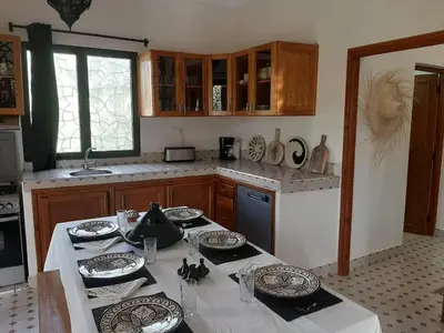 a kitchen with a table with plates on it at Villa privative el marjaa in Ouled el guerne