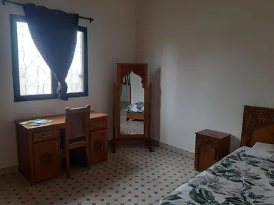 a bedroom with a bed and a desk and a mirror at Villa privative el marjaa in Ouled el guerne