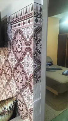 a wall in a room with a bedroom with a bed at appartement bab boujloud in Fès
