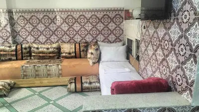 a bedroom with a bed and a curtain and a couch at appartement bab boujloud in Fès