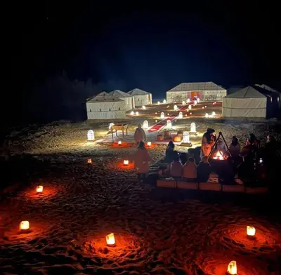 a group of people sitting on a beach with candles at Restaurant Food and Guide in Tisserdmine