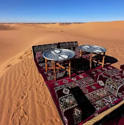 two tables on a blanket in the desert at Restaurant Food and Guide in Tisserdmine