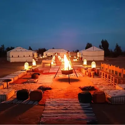 a group of tables with lights in a field at Restaurant Food and Guide in Tisserdmine