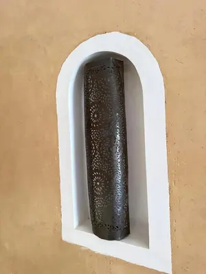 a black vase sitting in a white holder in a wall at Riad Azwaw in Er Rachidia