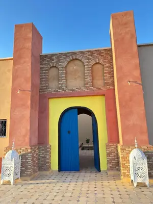 a building with a blue door in front of it at Riad Azwaw in Er Rachidia
