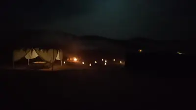 a night view of a house with lights in the dark at Merzouga camp in Merzouga