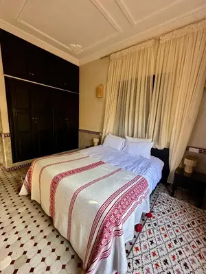 a bedroom with a large bed with curtains at Villa Atika in El Bougaria