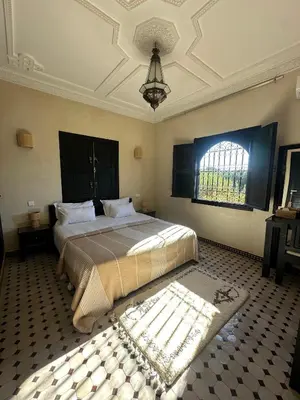 a bedroom with a large bed and a ceiling at Villa Atika in El Bougaria