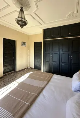 a large bed in a room with black doors at Villa Atika in El Bougaria