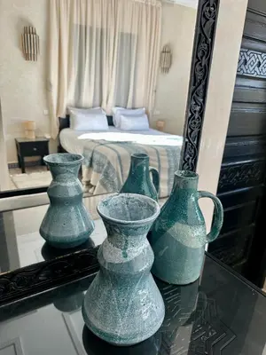 three vases sitting on a glass table in a bedroom at Villa Atika in El Bougaria