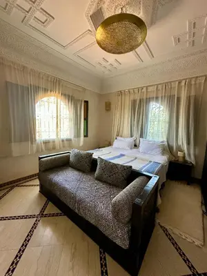 a bedroom with a bed and a couch in it at Villa Atika in El Bougaria
