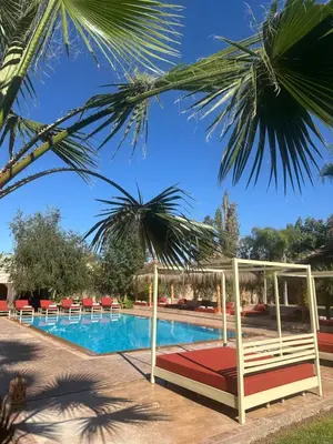 a resort pool with a bed and a canopy at Villa Atika in El Bougaria