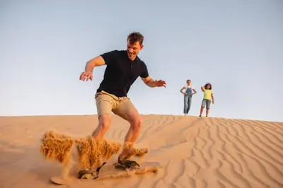 a man playing with a dog in the desert at Merzouga Twilight Camp in Merzouga