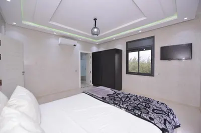 a bedroom with a bed and a flat screen tv at Villa Route de Fes in Marrakesh in Douar bel Rhanodour