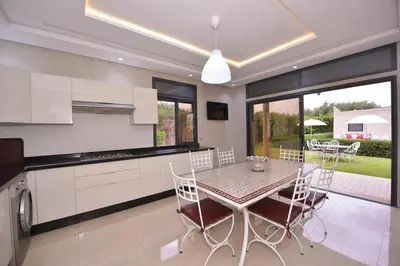 a kitchen and dining room with a table and chairs at Villa Route de Fes in Marrakesh in Douar bel Rhanodour