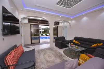 a living room with couches and a pool at Villa Route de Fes in Marrakesh in Douar bel Rhanodour