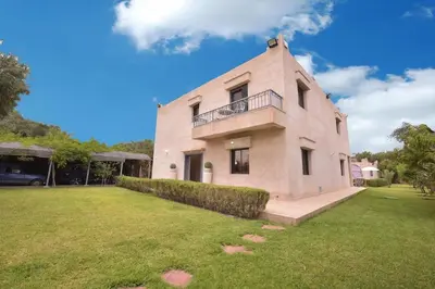 a large brick building with a balcony on top of a yard at Villa Route de Fes in Marrakesh in Douar bel Rhanodour