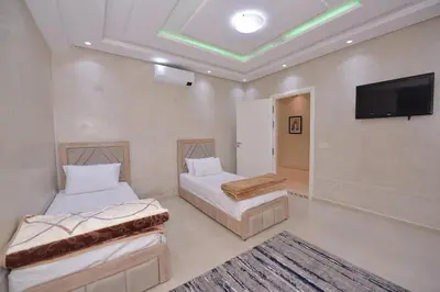 a bedroom with two beds and a flat screen tv at Villa Route de Fes in Marrakesh in Douar bel Rhanodour