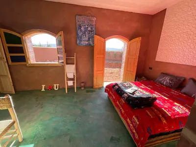 a bedroom with a bed in a room with windows at AISHAMA Healing House in Aït Ourir