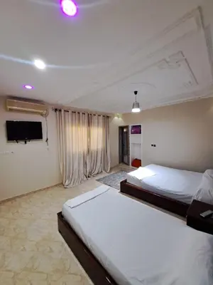 a bedroom with two beds and a flat screen tv at Villa HACHIMI in Erfoud