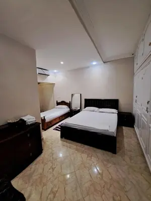 a bedroom with two beds and a dresser in it at Villa HACHIMI in Erfoud