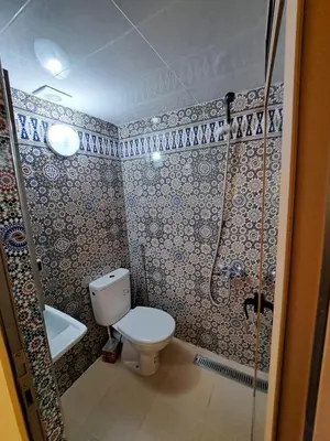 a bathroom with a toilet and a shower at Villa HACHIMI in Erfoud
