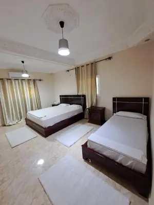 two beds in a room with two rugs at Villa HACHIMI in Erfoud