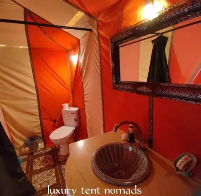 a bathroom with a sink and a toilet in a tent at Luxury tent nomads in Merzouga