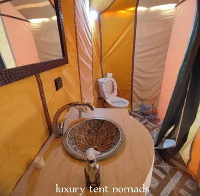a bathroom with a sink and a toilet in a tent at Luxury tent nomads in Merzouga