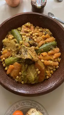 a bowl of food with beans and vegetables on a table at Hotel Berber Palace Merzouga in Merzouga
