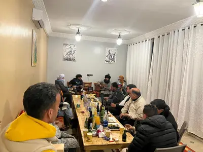 a group of people sitting at tables in a room at Hotel Berber Palace Merzouga in Merzouga