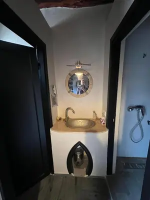 a bathroom with a sink and a person taking a picture at Dar louqman ourika in Asguine