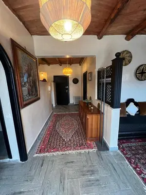 a living room with a large rug and a chandelier at Dar louqman ourika in Asguine