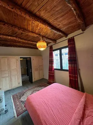a bedroom with a pink bed in a room at Dar louqman ourika in Asguine
