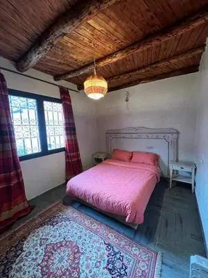 a bedroom with a pink bed and a rug at Dar louqman ourika in Asguine