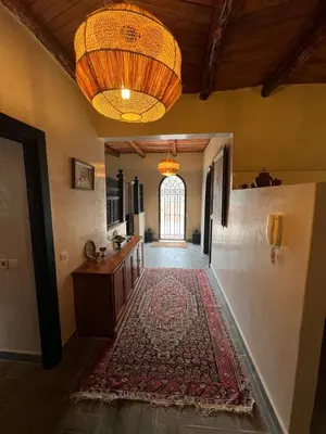 a hallway with a rug on the floor and a chandelier at Dar louqman ourika in Asguine