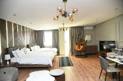 a bedroom with a large bed and a living room at Suite Bahiya 11 in Fès