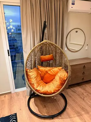 a hanging chair with orange sheets in a room at Suite Bahiya 11 in Fès