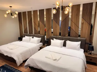 two beds in a hotel room with white sheets at Suite Bahiya 15 in Fès